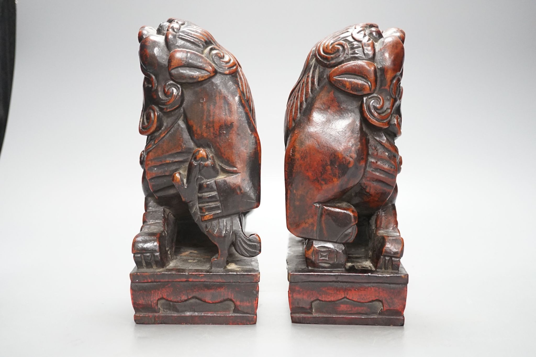 A pair of Japanese carved and red lacquered wood models of temple dogs, Edo period, 21.5 cms high.